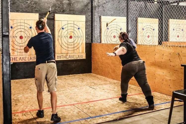 friends throwing axes at an indoor target