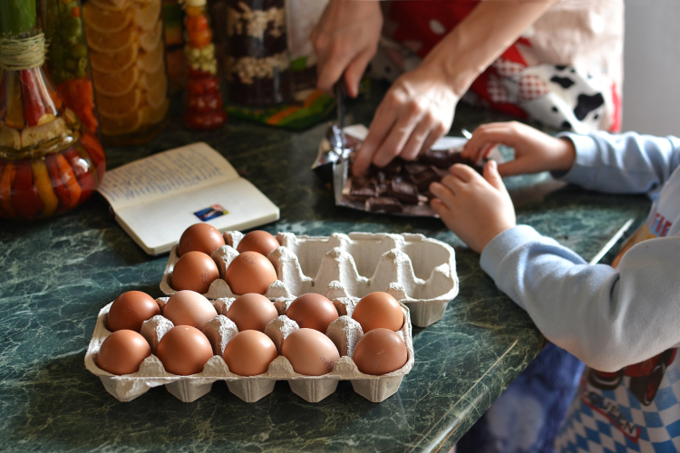 woman and child baking with chocolate and eggs