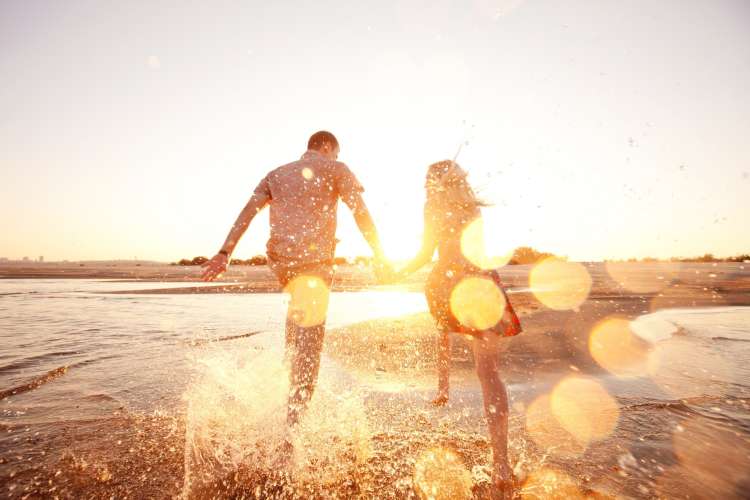 couple running along the beach at sunset