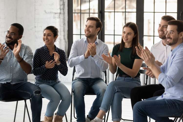 a diverse group of employees clap at a training seminar