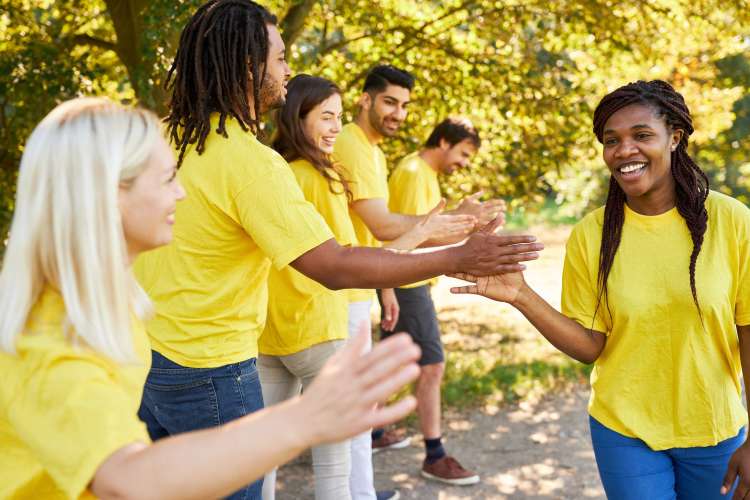 a team in yellow t-shirts goes down the line with high fives