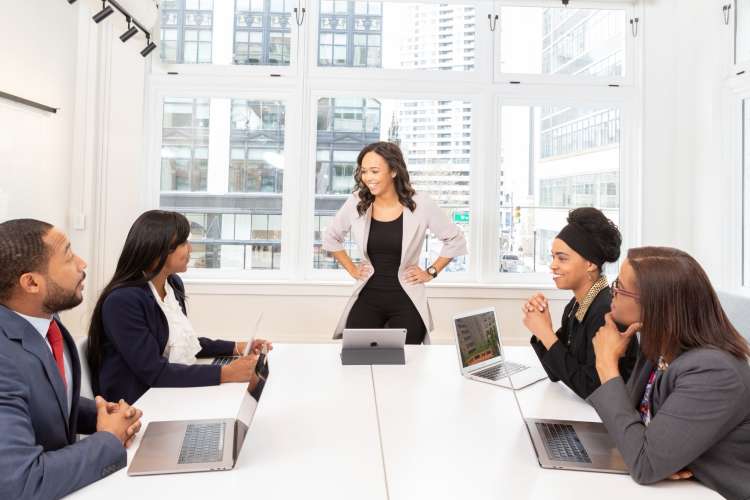 a professional woman smiles at her group of co-workers at a table