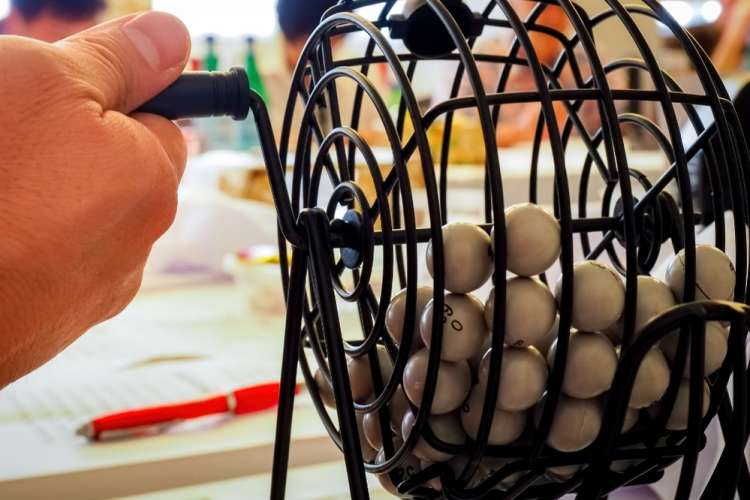 bingo caller rotating a wheel with numbered balls