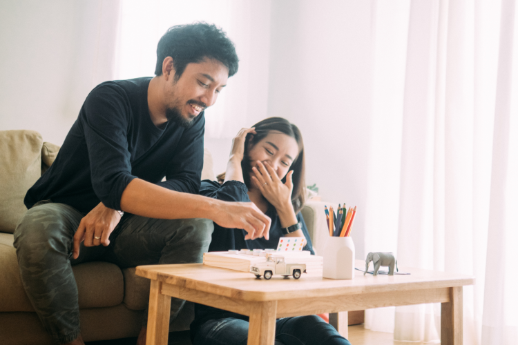 couple playing a board game at their coffee table