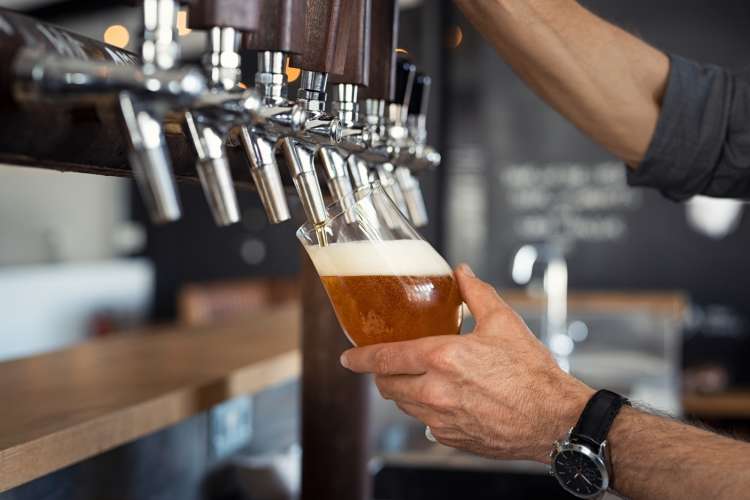 man pouring a beer at a craft brewery