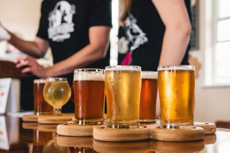 servers with a beer flight at a brewery