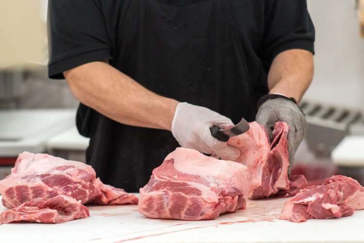 a butcher chef cutting meat