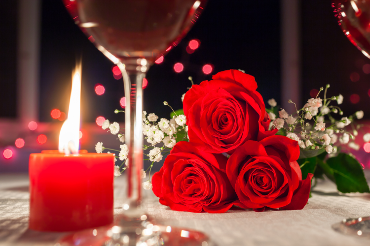 lit candles with roses on a table