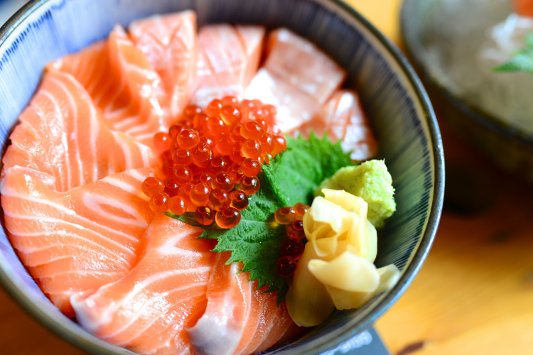 bowl of chirashi with fresh salmon, ginger, wasabi and roe