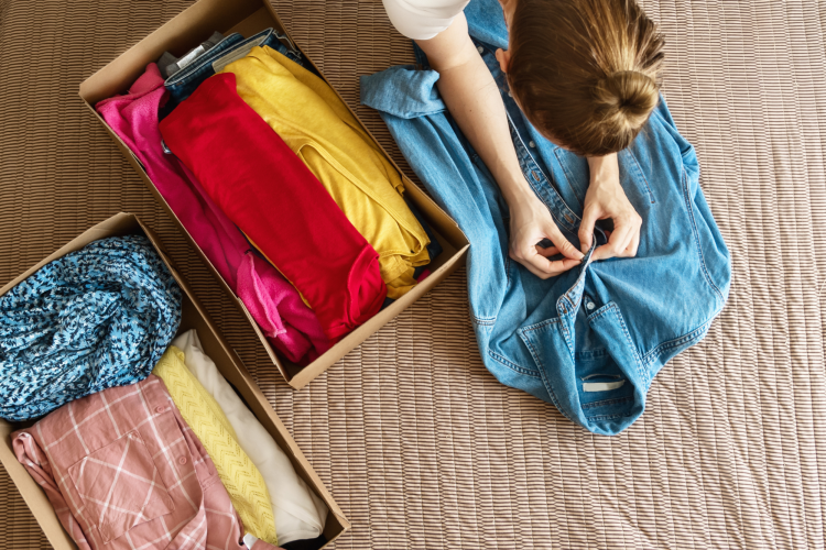 woman packing clothing for a clothes swap