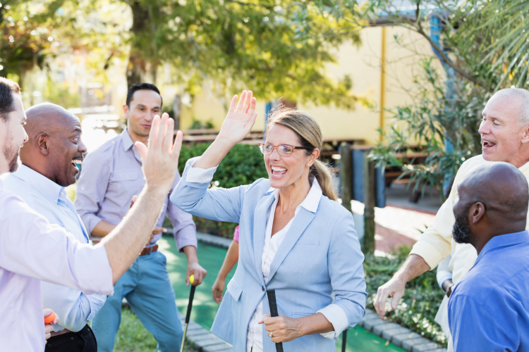 colleagues high-fiving while playing golf