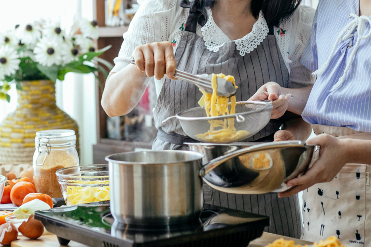 women cooking with a stainless steel pot