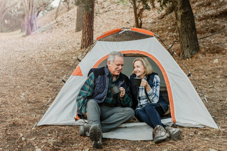 middle-aged couple sitting next to each other in a tent on a fall day