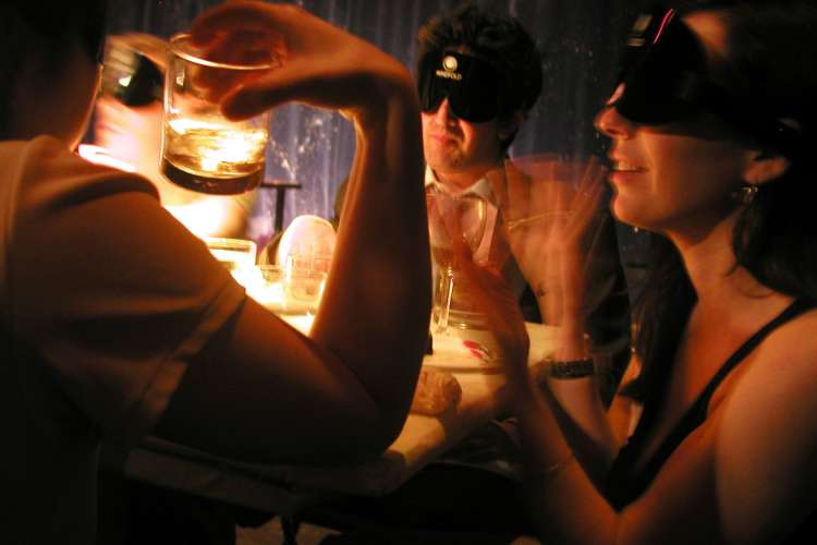 people eating while wearing blindfolds