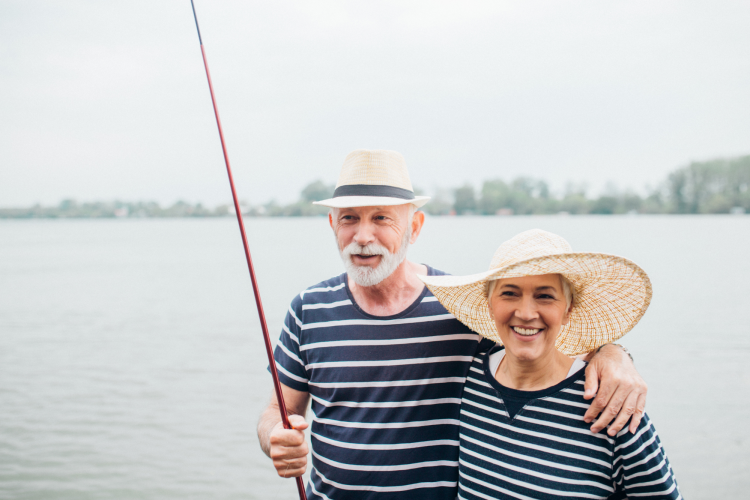 couple standing by the water's edge to go fishing