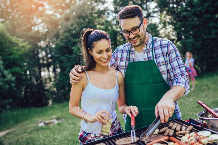 young couple grilling together on the barbecue