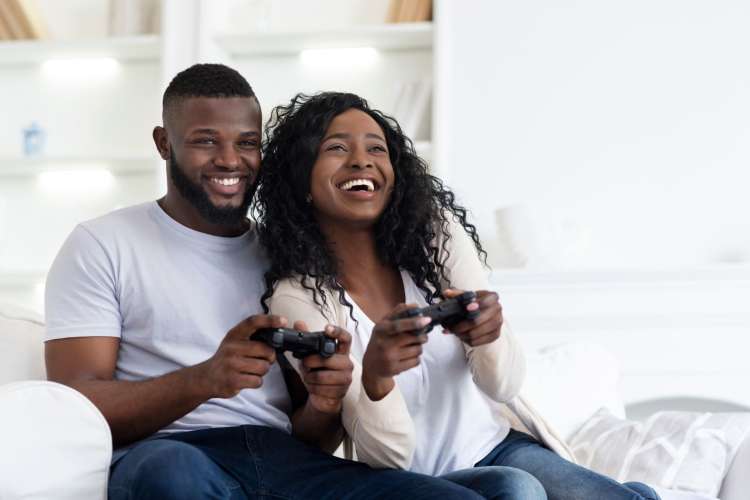 a couple playing a video game together on the couch