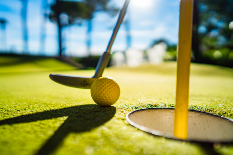 playing a round of golf on the putting green