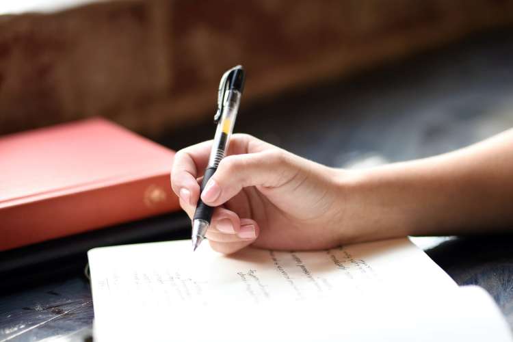 woman writing notes in a one-line-a-day journal