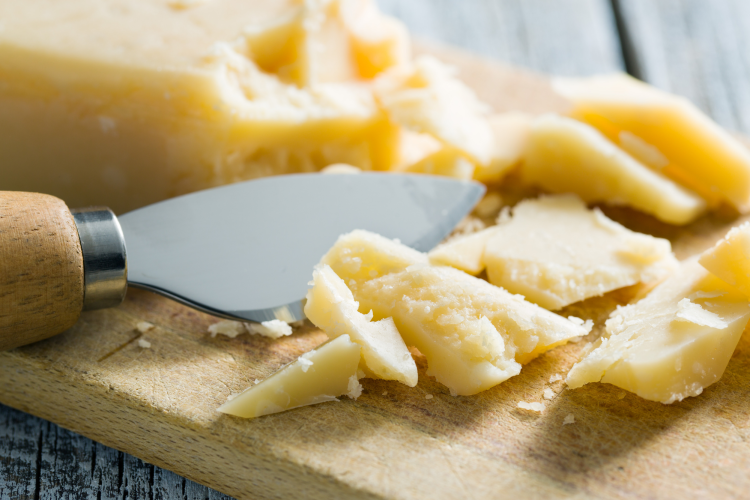 A heart knife on a board with cheese