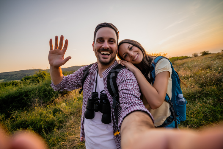 couple waving to camera on a hike