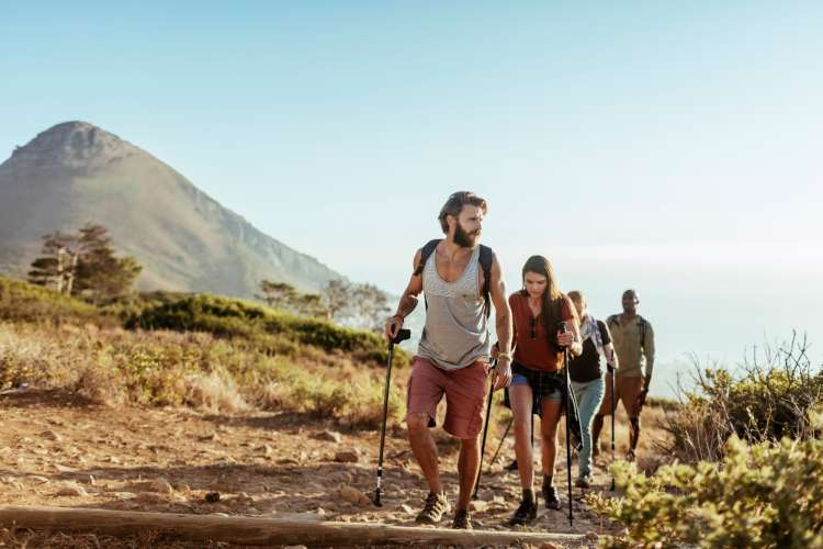 group of friends hiking in front of a mountain