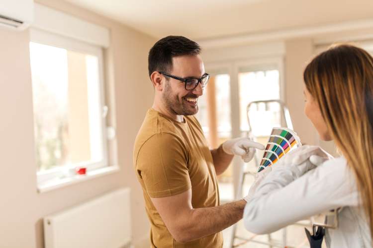 couple painting the walls of their home blue