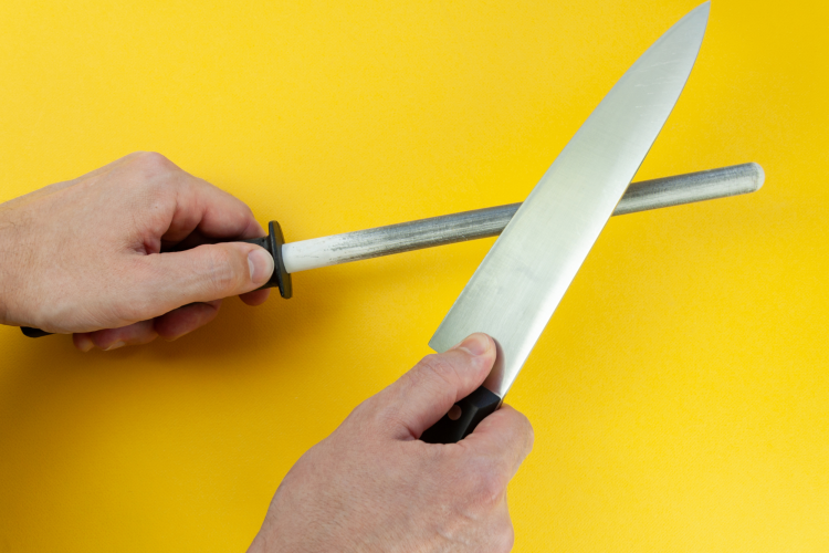 chef using honing rod on a knife