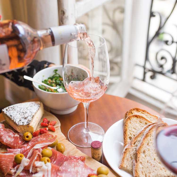 pouring a glass of rose wine at a private home wine and cheese tasting