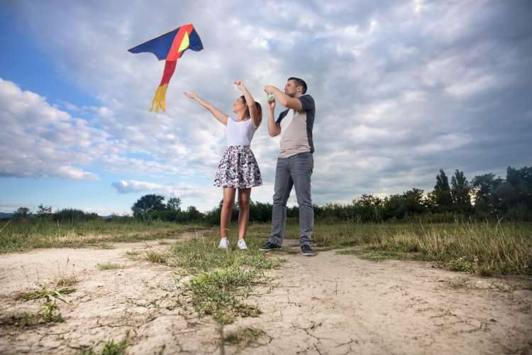 a couple flying a kite together