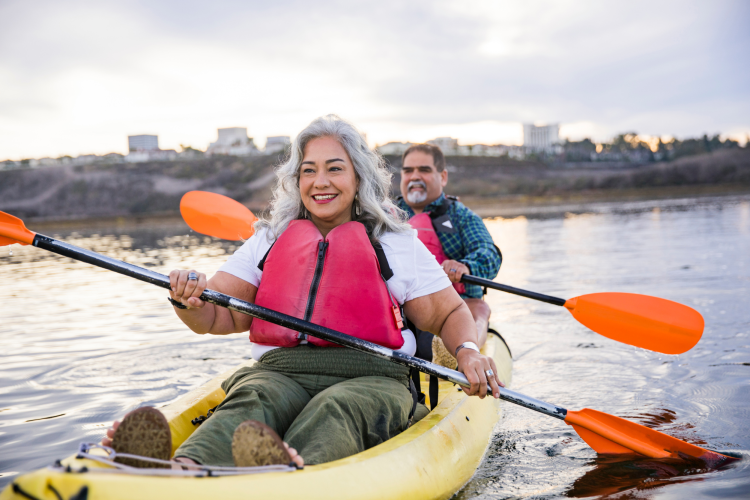 middle-aged couple kayaking on a river