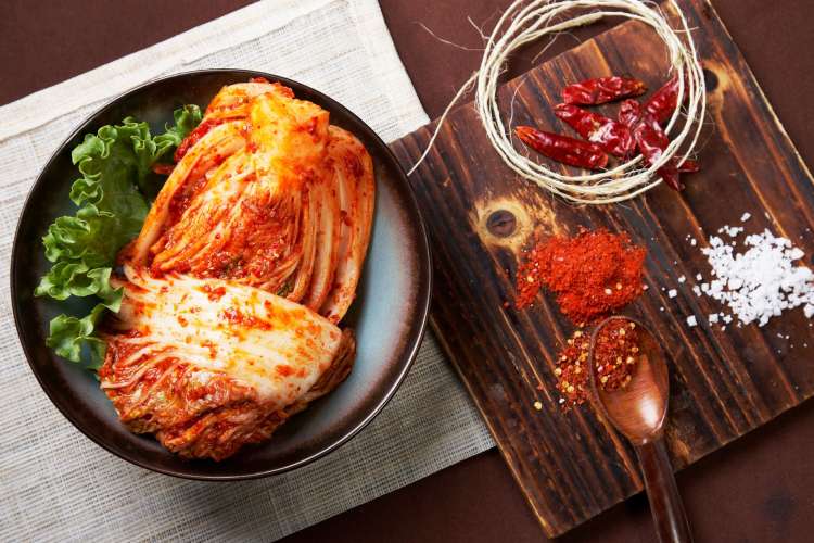 kimchi beside its main parts, red chili flakes, chili powder, salt and red peppers