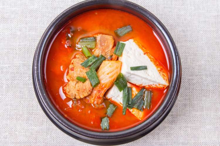 a bowl of red colored kimchi stew 