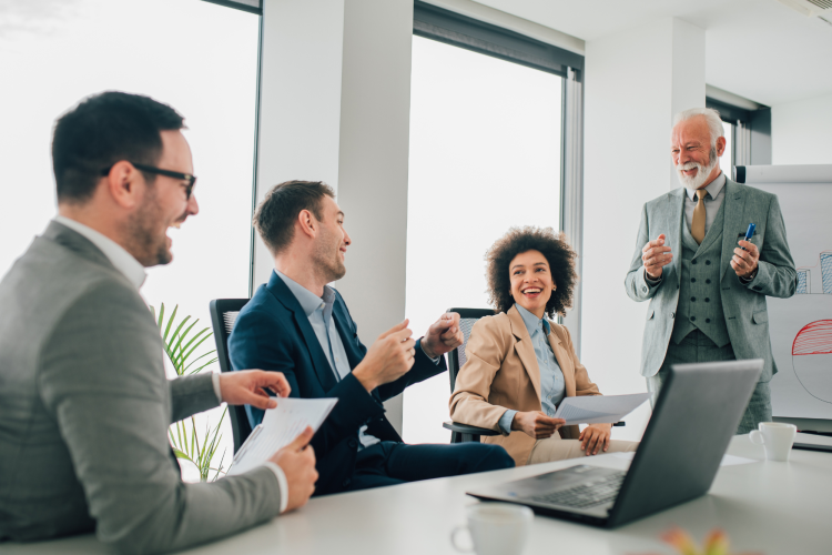 happy looking professionals of diverse ages around a desk