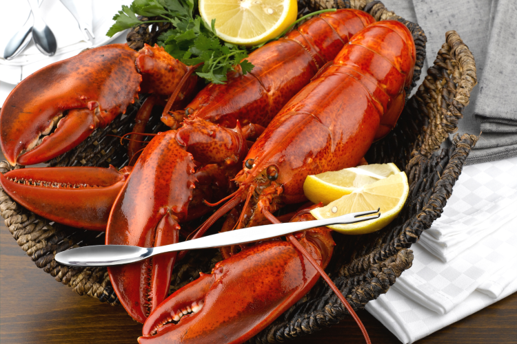 steamed lobsters in a bakset with lemon and seafood fork