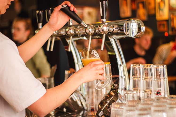 bartender pouring draft beer from a tap