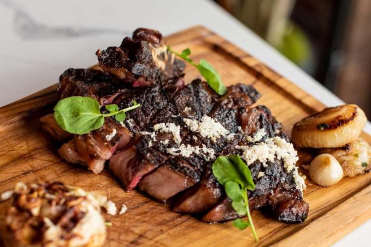 steak on a cutting board at loulou nyc