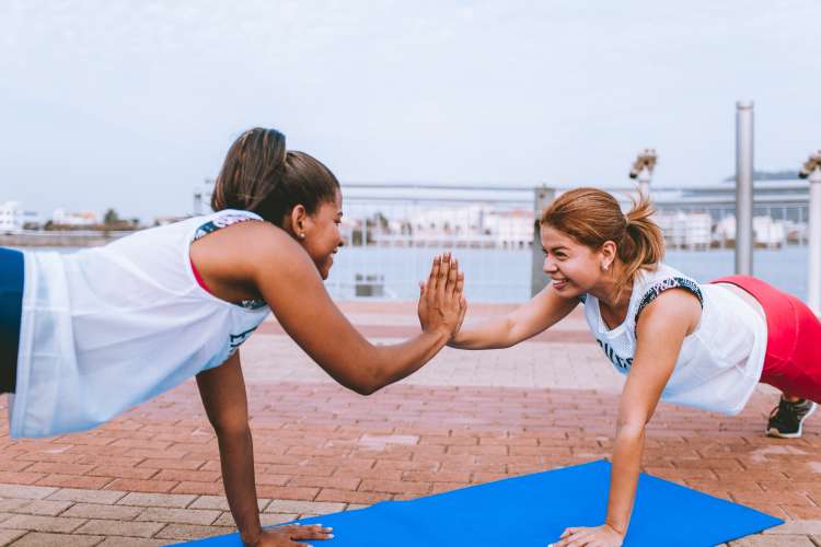 women high-fiving while exercising together