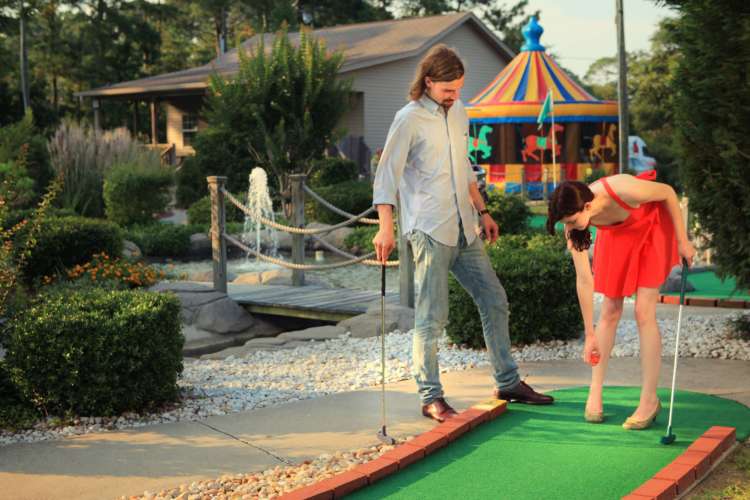 a couple playing mini golf as an alphabet date idea for m