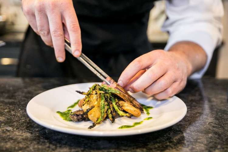 new york city chef plating food in a restaurant