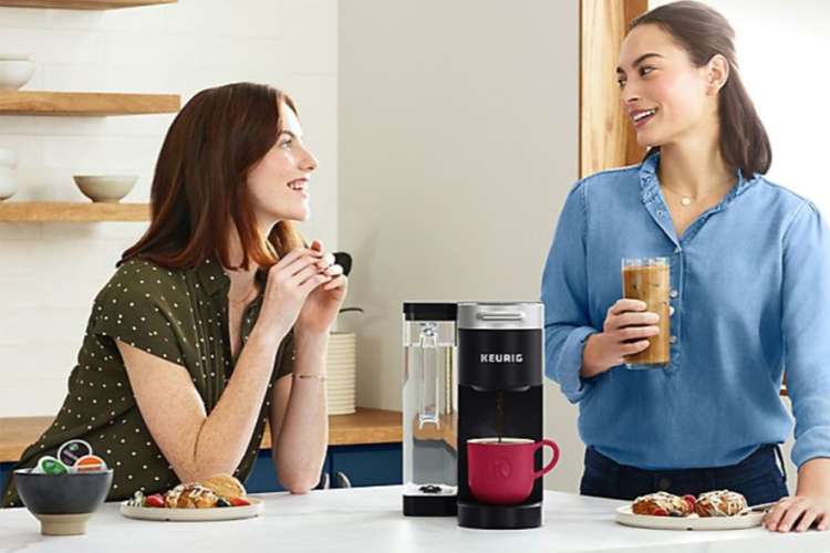 woman chatting in front of a keurig coffee machine on the counter