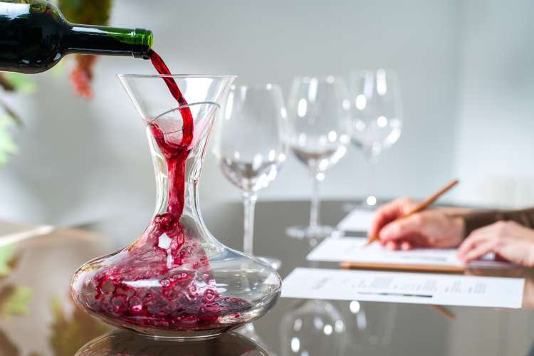 wine being poured into a decanter for a wine tasting