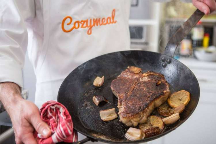 a chef displaying a charbroiled steak with 