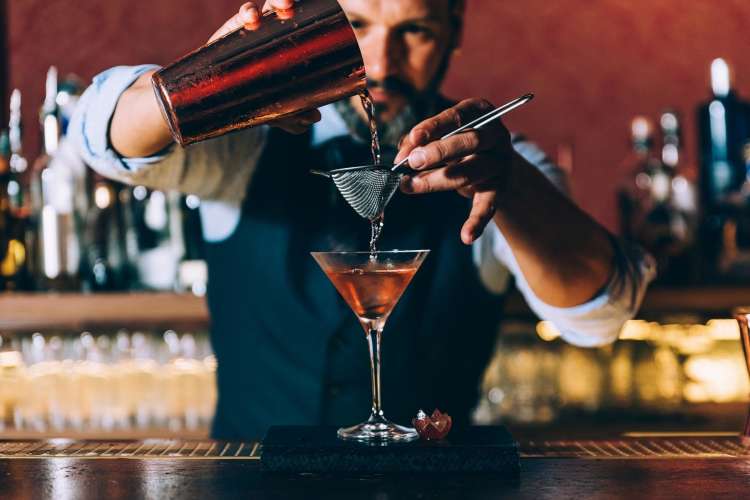 bartender pouring a cocktail