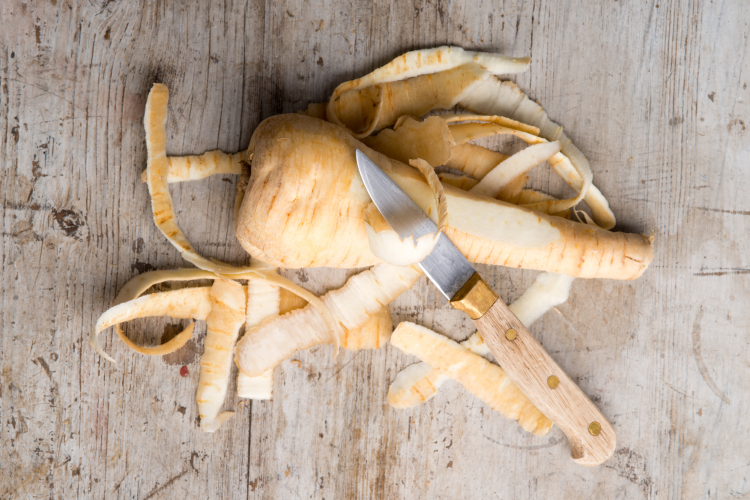 peeling a parsnip with a paring knife