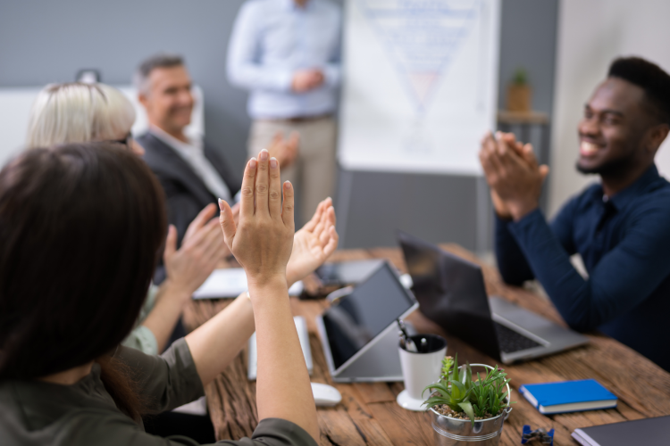 colleagues clapping for each other during a peer recognition program