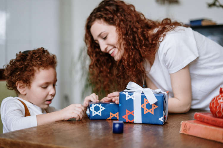 mother and young daughter wrapping Chanukah presents 