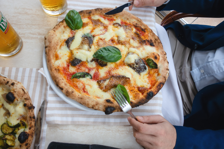 man enjoying pizza in naples, italy