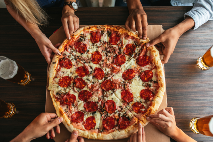 friends enjoying slices of pizza