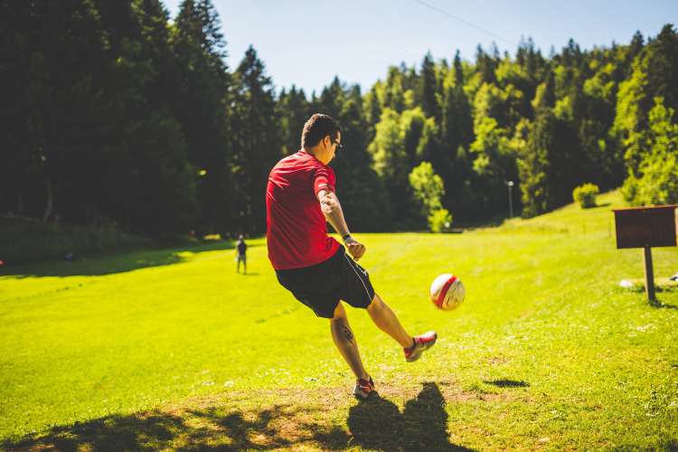 kicking a ball while playing a team building activity